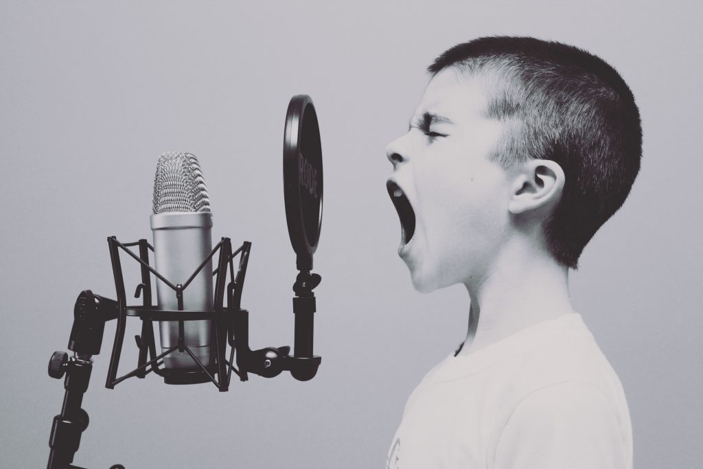 Boy screaming to the microphone.